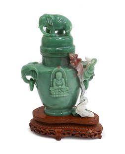 Chinese Carved Jade Decorative Urn on Base: Chinese Carved Jade Decorative Urn on Base. Figural elephant finial and handles with a carved relief Buddah to center. Mounted on a wood base. Weight Approx., 2 lbs Measures Approx., 6 inches x 2.5 in