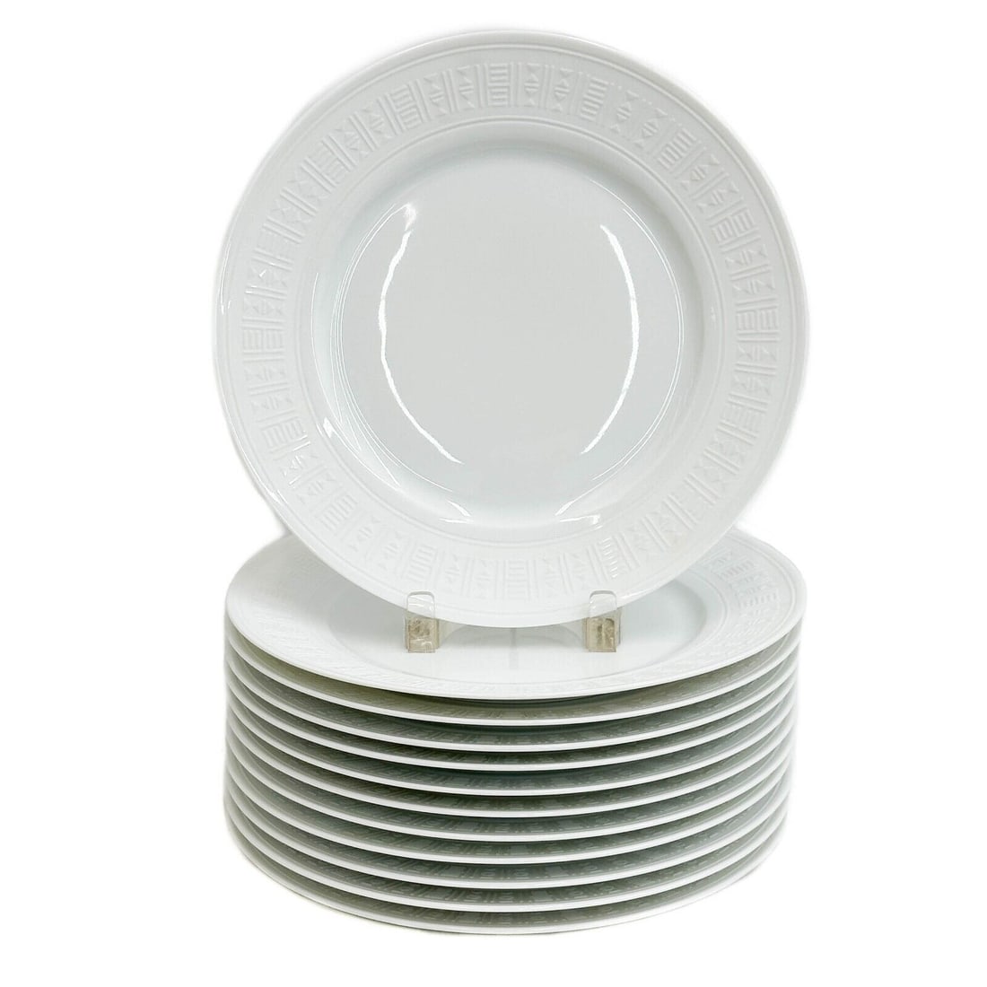 12 Hermes Paris Porcelain Dinner Plates Egee White: 12 Hermes Paris Porcelain Dinner Plates in Egee. White porcelain plates, raised geometric decoration to the edge. Underside marked Hermes Egee. Weight: Approx. 17.5 lbs Measurements: Approx. 10.75 inc