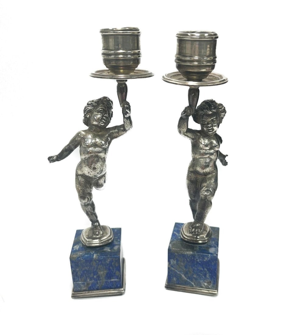 Pair Buccellati Italian Sterling Silver Lapis Lazuli Veneered Candlesticks: Pair Buccellati Italian sterling silver and Lapis Lazuli veneered candlesticks, circa 1950. Figural cherubs to the stem holding up the bobeches in a dancing manner. Venered Lapis Lazuli panels to the