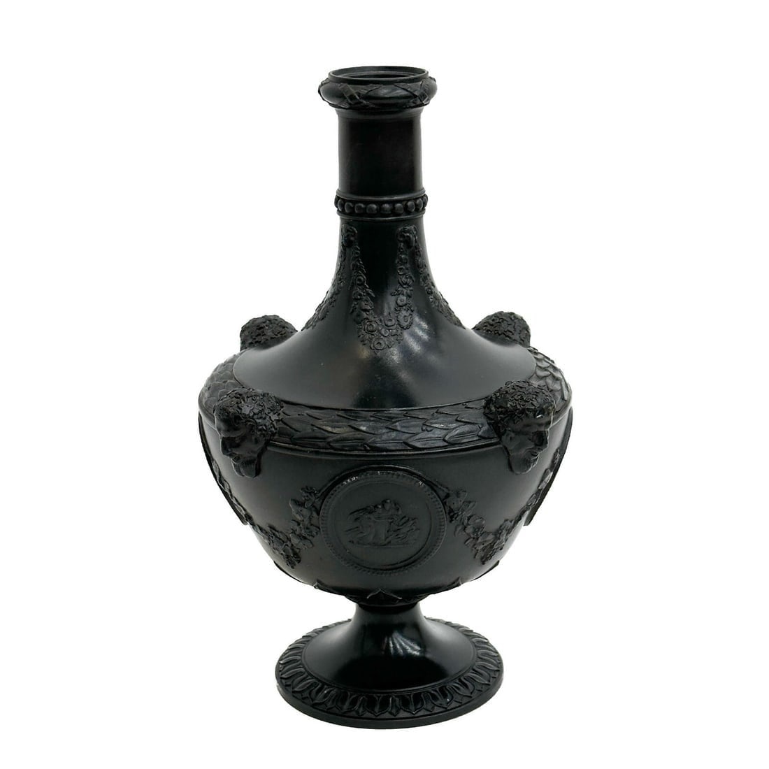 Wedgwood England Black Basalt Neoclassical Urn 19th century: Wedgwood England Black Basalt Neoclassical Urn, 19th century. Figural heads to edges, medallions with scenes of figures to the sides, garland swags. Underside marked Wedgwood Weight: Approx. 2.5 lbs M