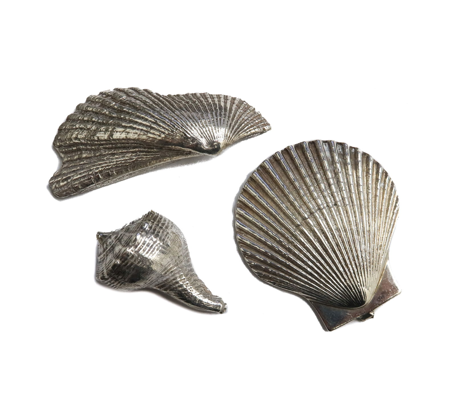 3 Sterling Silver Shell Figurines: 3 Sterling Silver Shell Figurines. Depicts two scallop shells and one conch shell. Each marked sterling. Weight Approx., 30 grams Measures Approx., Big Shell: 1.5 inches x 1.325 inches / Long Shell: 1