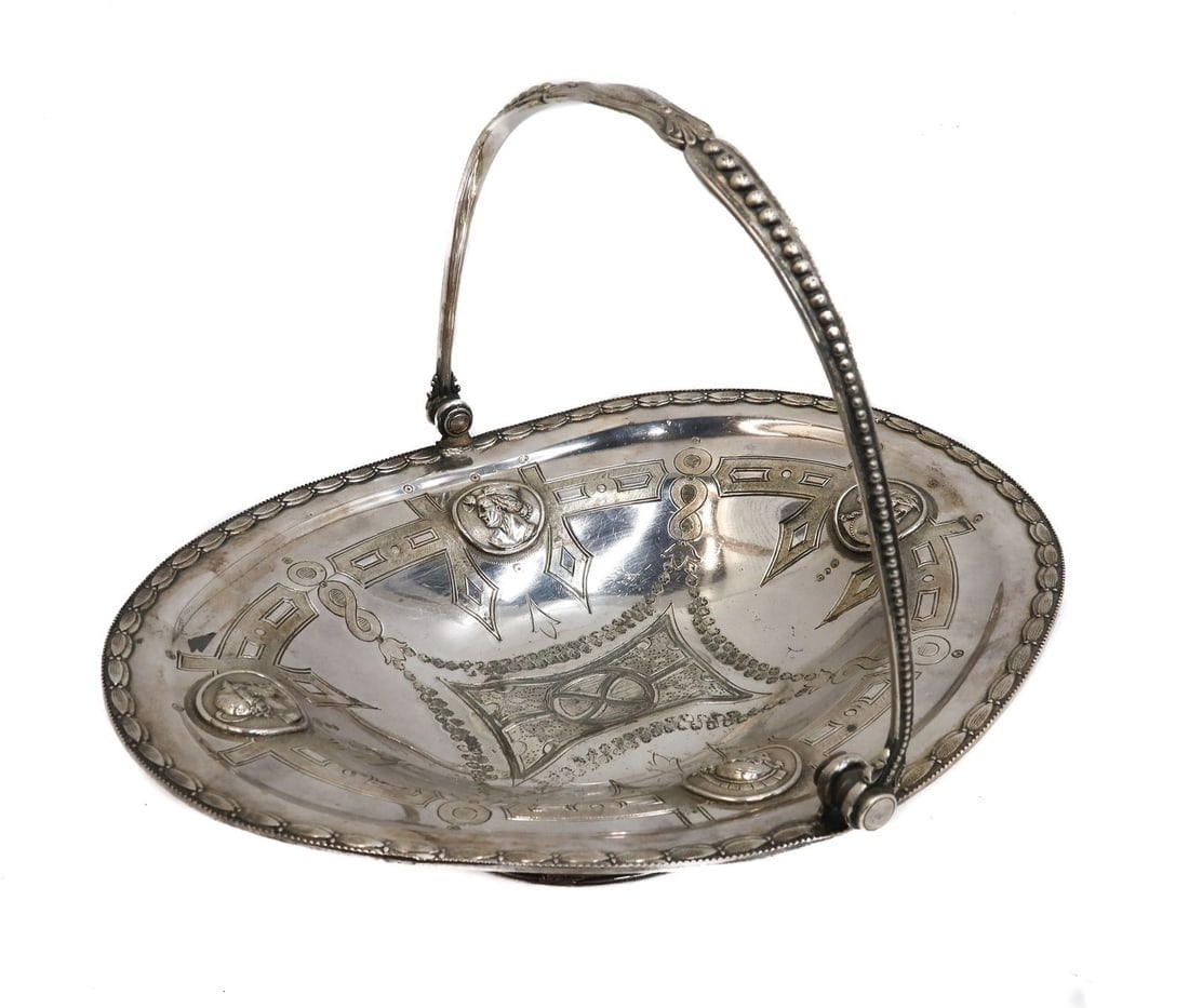 Meriden Britannia Co. Silver Plate Swing Handled Footed Basket Mid Century: Meriden Britannia Co. Silver Plate Swing Handled Footed Basket Mid Century. Medallions rim of bowl with etched laureal leaf swags and a leaf beaded rim. Meriden Britannia mark to underside. Weight App