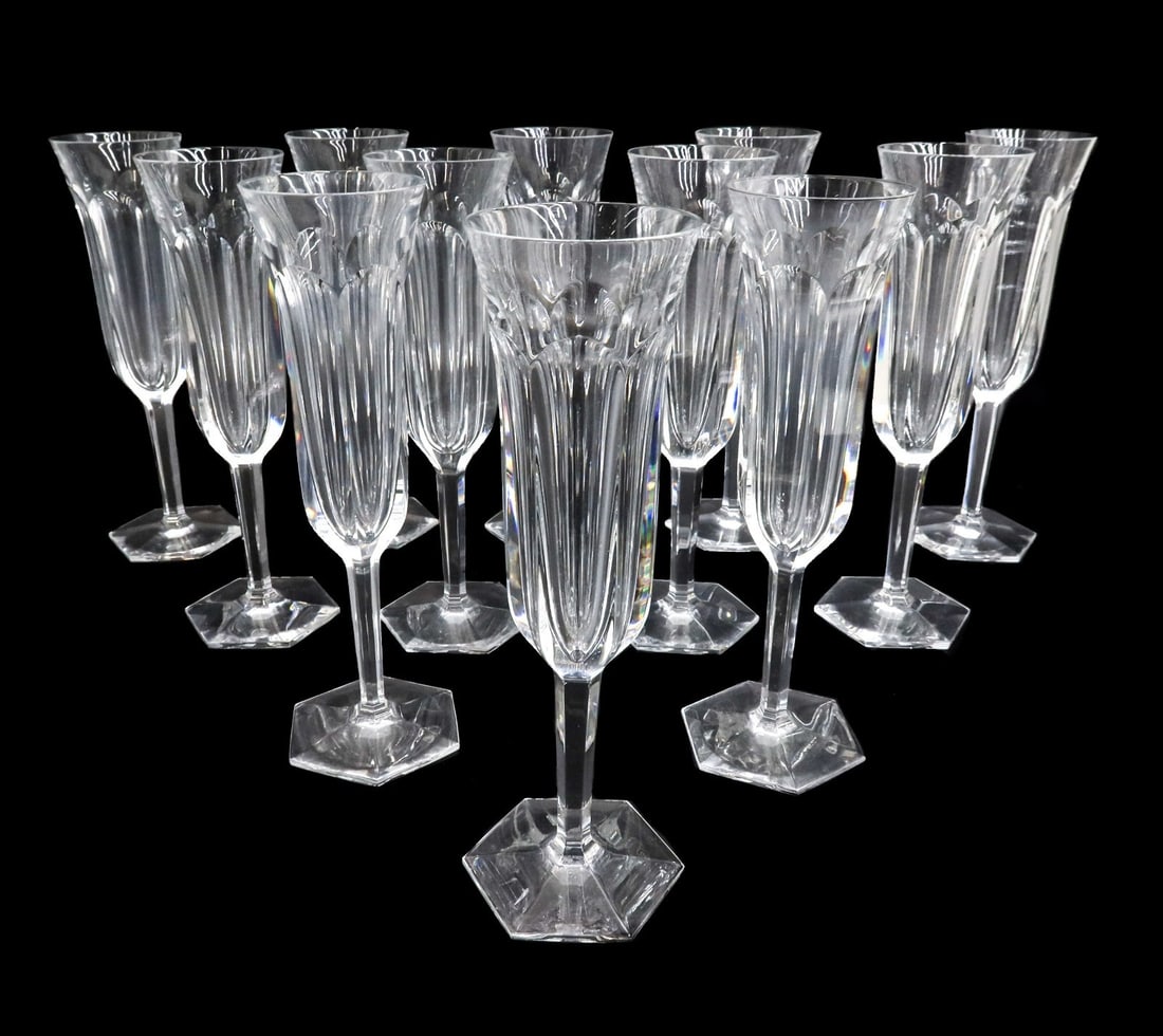 12 Baccarat France Cut Glass Champagne Flutes in Malmaison Signed: 12 Baccarat France cut glass champagne flutes in Malmaison. Cut glass thumbprints to exterior of bowl with hexagonal base. Acid etched Baccarat mark to underside. Weight: Approx. 8 lbs Measurements: