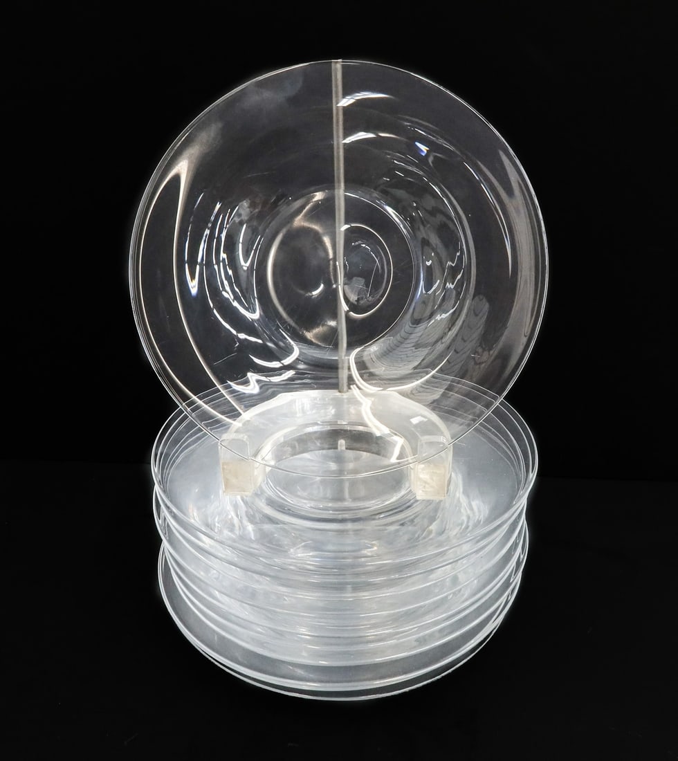 11 Steuben Colorless Crystal Glass 7 inch Plates Signed: 11 Steuben colorless crystal glass 7 inch plates, signed. Marked "S" to underside. Weight: Approx. 6 lbs Measurements: Approx. 7 inches diameter Condition: Good condition. Moderate surface and utensil