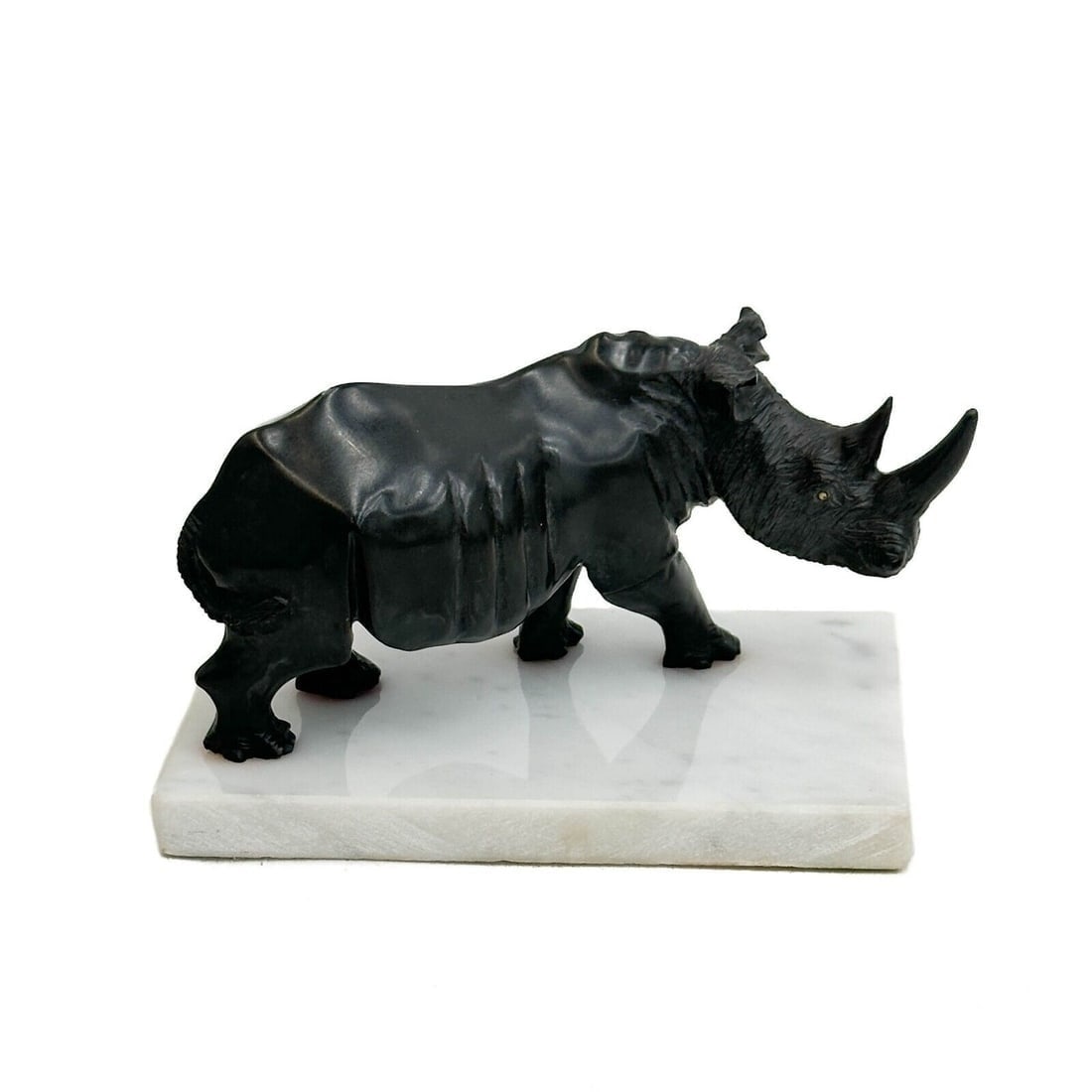 Black Wonderstone Carved Figurine of a Rhinoceros / Rhino White Marble Base: Contemporary Black Wonderstone Carved Figurine of a Rhinoceros, mounted on a white marble base. Weight: Approx. 2.5 lbs Measurements: approx. 6 inches x 4 inches base x 3.5 inches tall Condition: nick