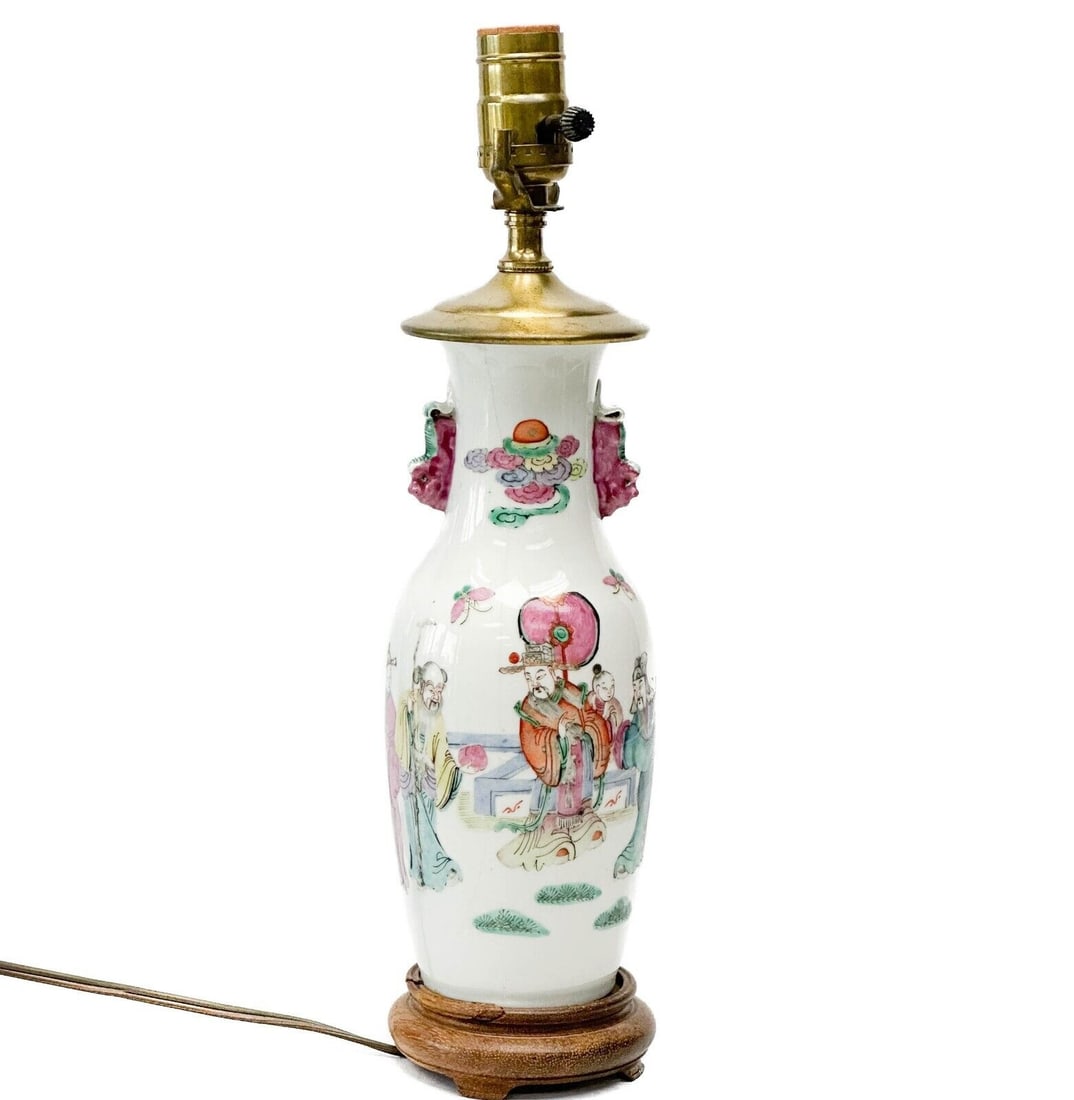Chinese Hand Painted Porcelain Vase Mounted as a Lamp Figures: Chinese hand painted porcelain vase mounted as a lamp. Wood base, gilt bronze mounts. A white ground decorated with figures, figural handles. Tested with light bulbs and is functional. Weight Approx.,