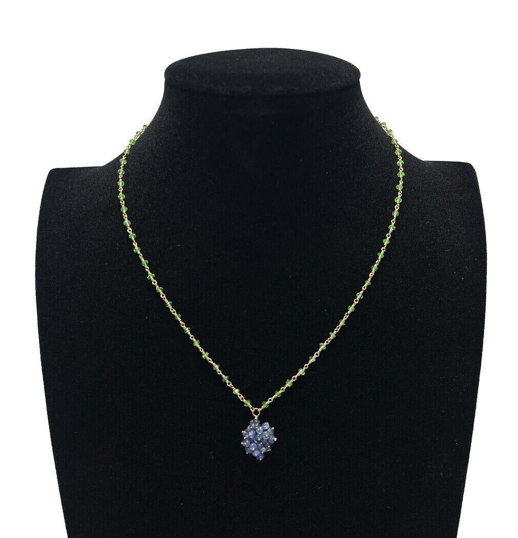 SMJim 14k Yellow Gold Peridot and Blue Tanzanite Necklace: SMJim 14k yellow gold peridot and blue tanzanite necklace. Peridot jewels to the strand with and blue tanzanite to the pendant in the form of berries. Marked "SMJim" to either side of 8the heart clasp