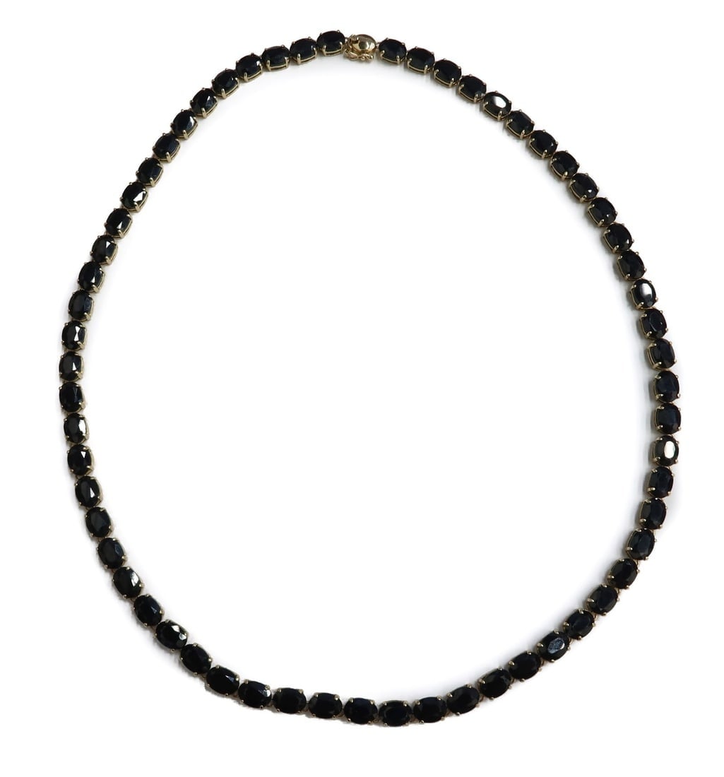 14k Yellow Gold and Blue Sapphire Necklace: 14k Yellow Gold and Blue Sapphire Necklace. 61 dark blue sapphires that measure approximately 6.9mm x 5mm x 3.1mm and weighs around 52.46 carats. Marked 14k to clasp. Weight Approx., 23.67 grams Measu