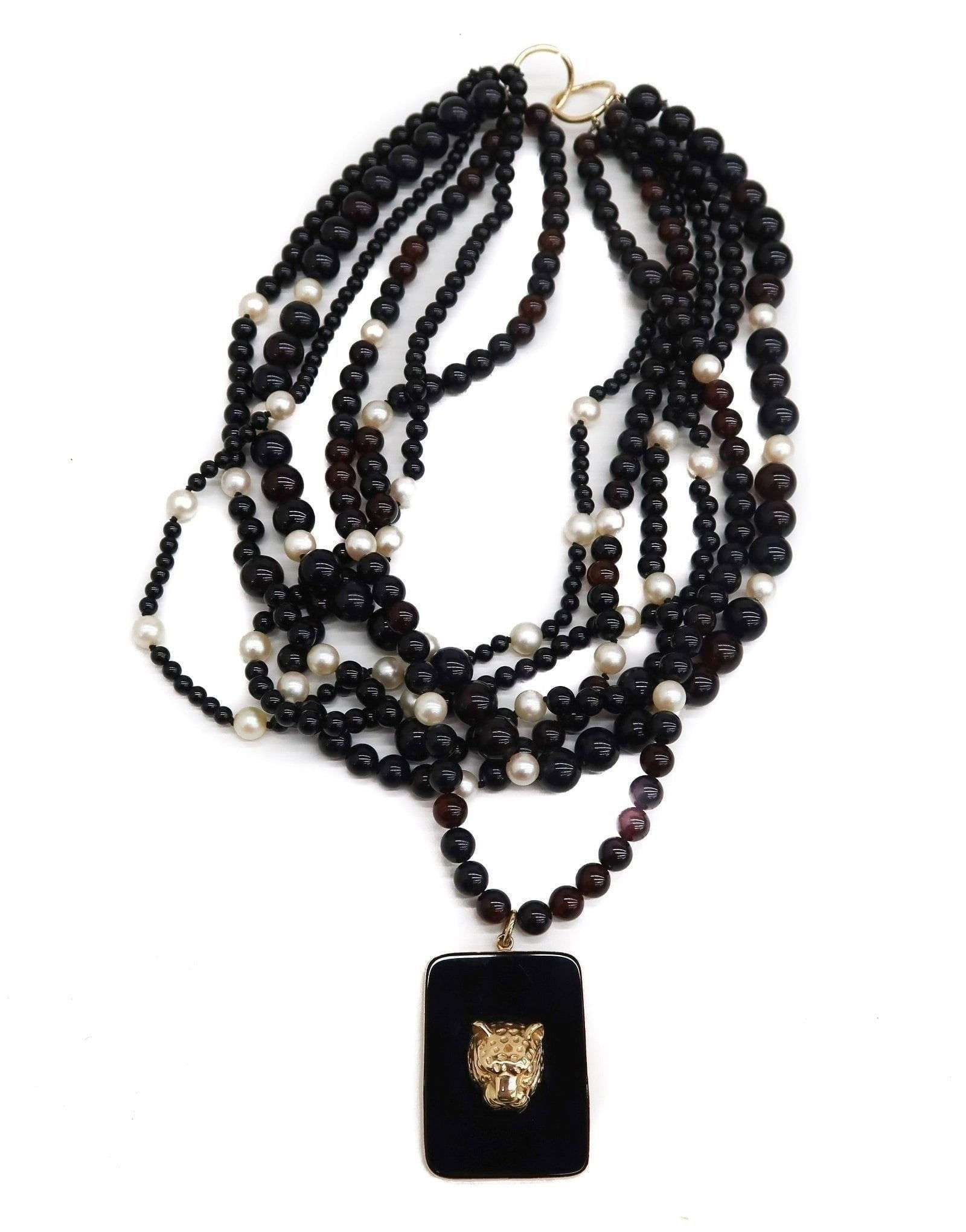 14k Yellow Gold Black and Red Garnet Multistrand Necklace, Jaguar Pendant: 14k Yellow Gold Black and Red Garnet Multistrand Necklace, Jaguar Pendant. Multistrand garnet necklace measuring from 4.3mm to 9.5mm. Cultured pearl spacers. The center of the necklace with a jaguar p