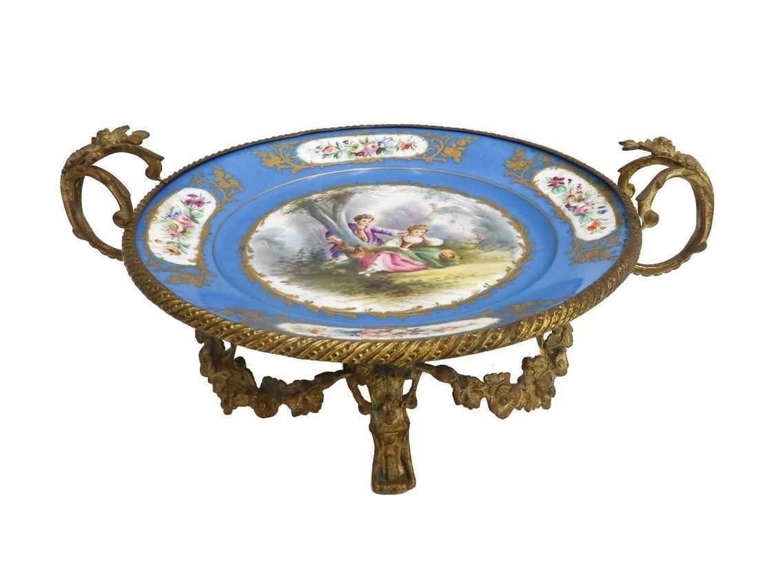 Sevres Porcelain Hand Painted Gilt Bronze Mounted Twin Handled Dish c1900: Sevres porcelain hand painted gilt bronze mounted twin handled dish, circa 1900. A sky blue ground with hand painted florals to rim and a courting scene to center. Mounted to a gilt bronze swag mounte