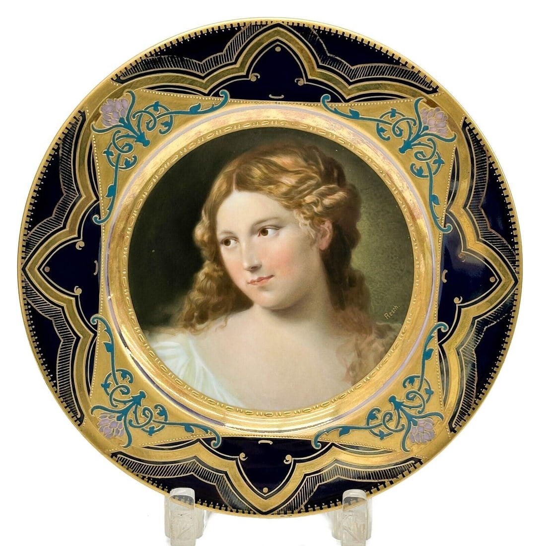 Royal Vienna Austria Hand Painted Porcelain Portrait Plate Beauty circa 1920: Royal Vienna Austria Hand Painted Porcelain Portrait Plate, circa 1920. A blue ground to the edge, pink and teal blue enameled florals, gilt accents. Hand painted portrait of a beauty to the center, a