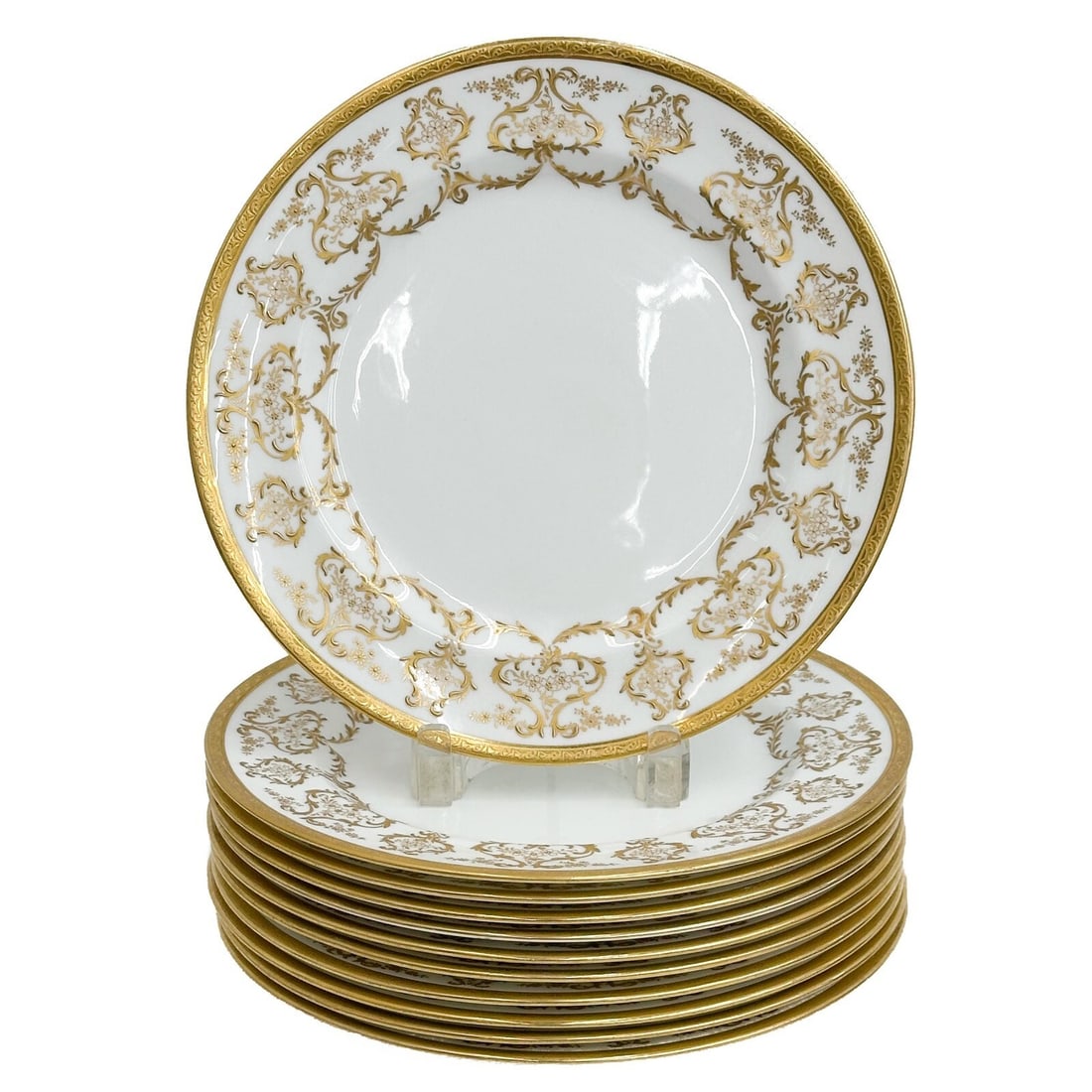 11 Royal Doulton England Gilt Porcelain Dinner Plates circa 1910: 11 Royal Doulton England Gilt Porcelain Dinner Plates, circa 1910. A white ground decorated with ornate raised gilt decoration to the edge. Underside marked for Royal Doulton, Higgins & Seiter Retaile