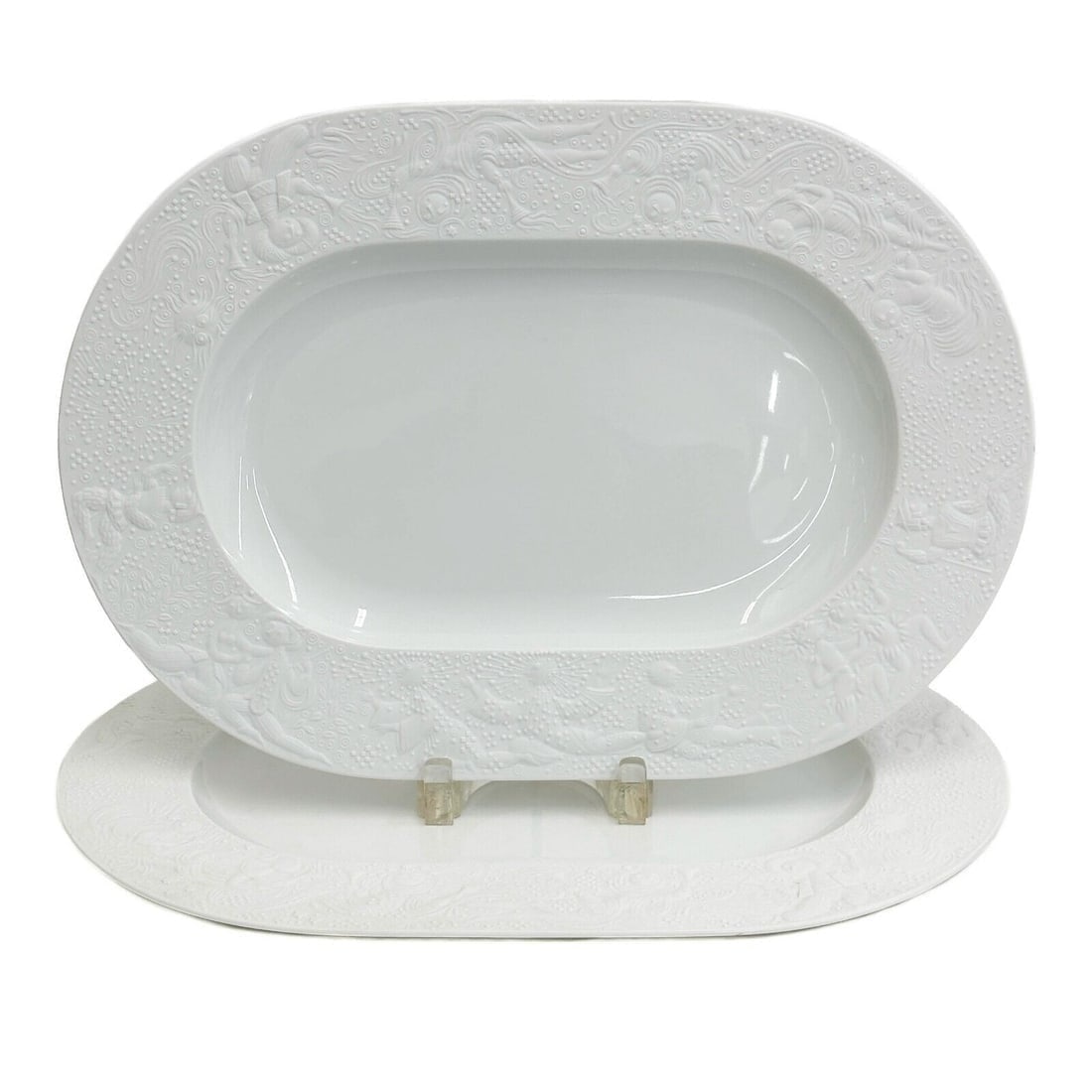 Pair Rosenthal Germany Porcelain 16 inch Oval Serving Platters Magic Flute White: Pair Rosenthal Germany Porcelain 16 inch Oval Serving Platters. White porcelain with embossed figures around the exterior with a matte finish. Underside marked Rosenthal Germany, Bijorn Wiinblad. Weig