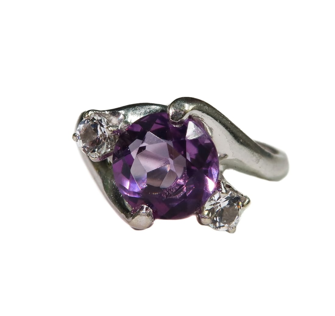 14k White Gold Amethyst and Tourmaline Ring Size 4.5: 14k White Gold Amethyst and Tourmaline Ring Size 4.5. Round cut amethyst center measuring approximately 7.5mm and weighing approximately 1.29 carats. Two round white tourmaline to either side measure