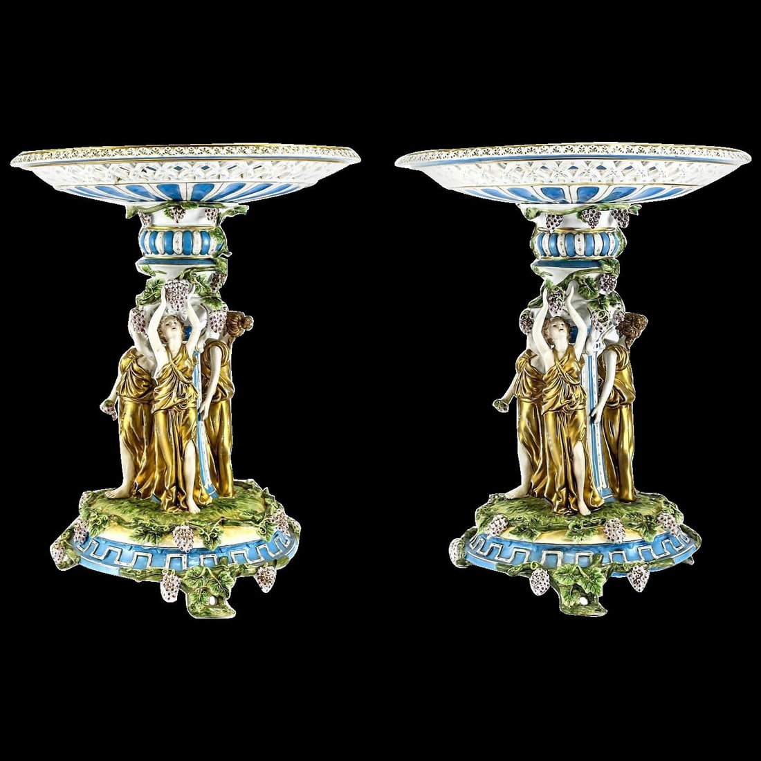 Pair of German Porcelain Bacchantes Tazza or Stand: Pair of German large porcelain figural bacchantes circa 1910 with raised shallow pierced and floral bowls. Hand-painted gilt three deity figures with grape and leaf accents. Crossed swords marks to ea