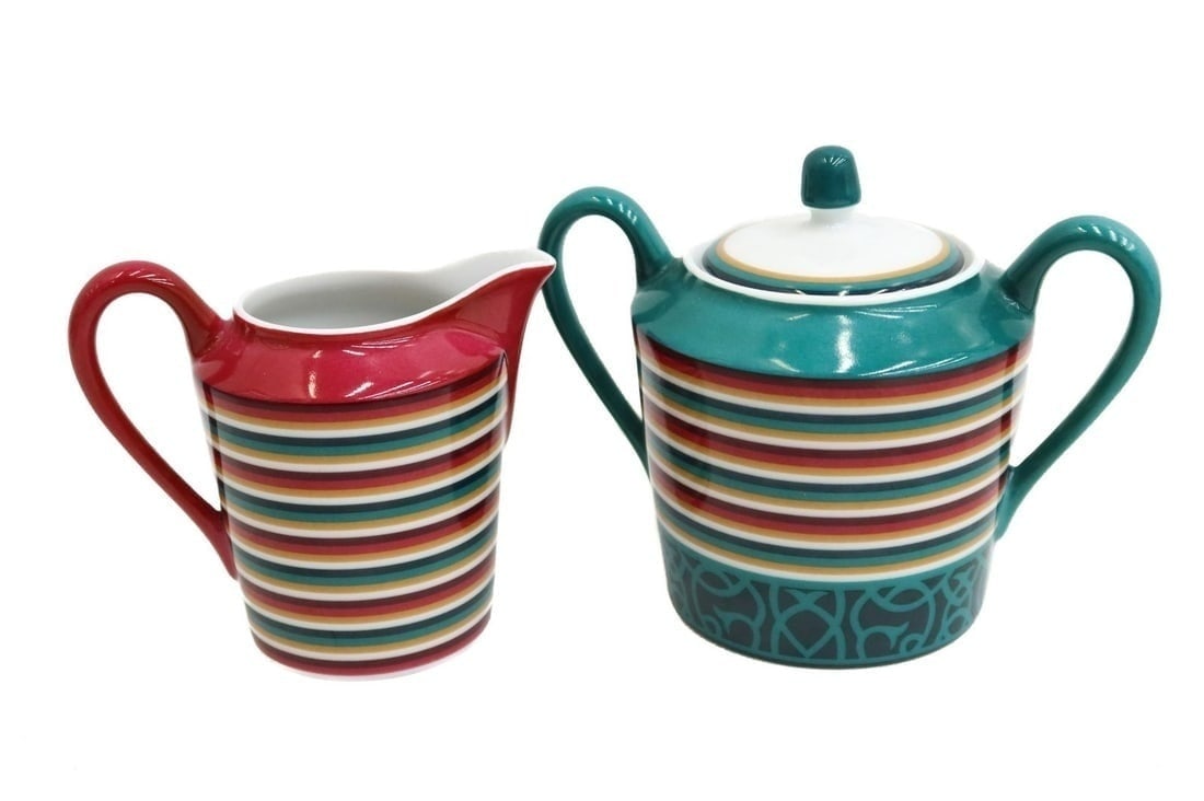 Hermes Paris Porcelain Sugar Bowl and Creamer in Attelage Green and Red Stripes: Hermes Paris porcelain sugar bowl and creamer in Attelage. Red and green stripes to rim. Hermes mark to underside. Weight Approx., 1 lbs Measures Approx., Sugar Bowl: 5.5 inches x 3.5 inches diameter 