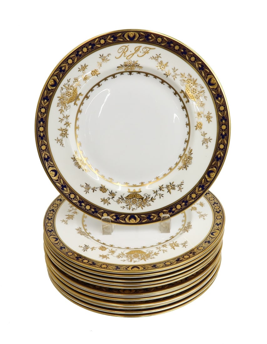 13 Minton England Porcelain Gold Encrusted Dinner Plates in Dynasty: 13 Minton England porcelain salad or dessert plates in Dynasty, Mid Century. Cobalt blue ground to rim with gold encrusted florals. 3 letter monogram "RJF" to center. Minton England mark to underside.