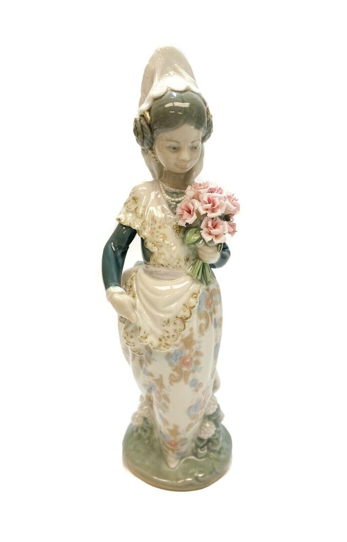 Lladro Spain Porcelain Valencianita Ofrenda Figurine #1304, Girl with Bouquet: Lladro Spain porcelain Valencianita Ofrenda Figurine #1304. The figurine depicts a veiled girl holding a bouquet of pink flowers. Lladro mark to the underside. Weight: Approx. 1 lb Measurements: Appro