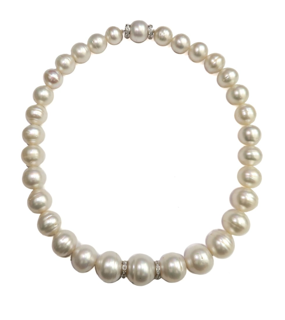 18k White Gold Graduated Semi-Baroque Cultured Pearl and Diamond Necklace: 18k white gold graduated semi-baroque cultured pearl and diamond necklace. 32 semi-baroque cultured pearls with a creamy white overtone measuring from 12.01mm to 17.53mm. 4 white gold spacers with enc