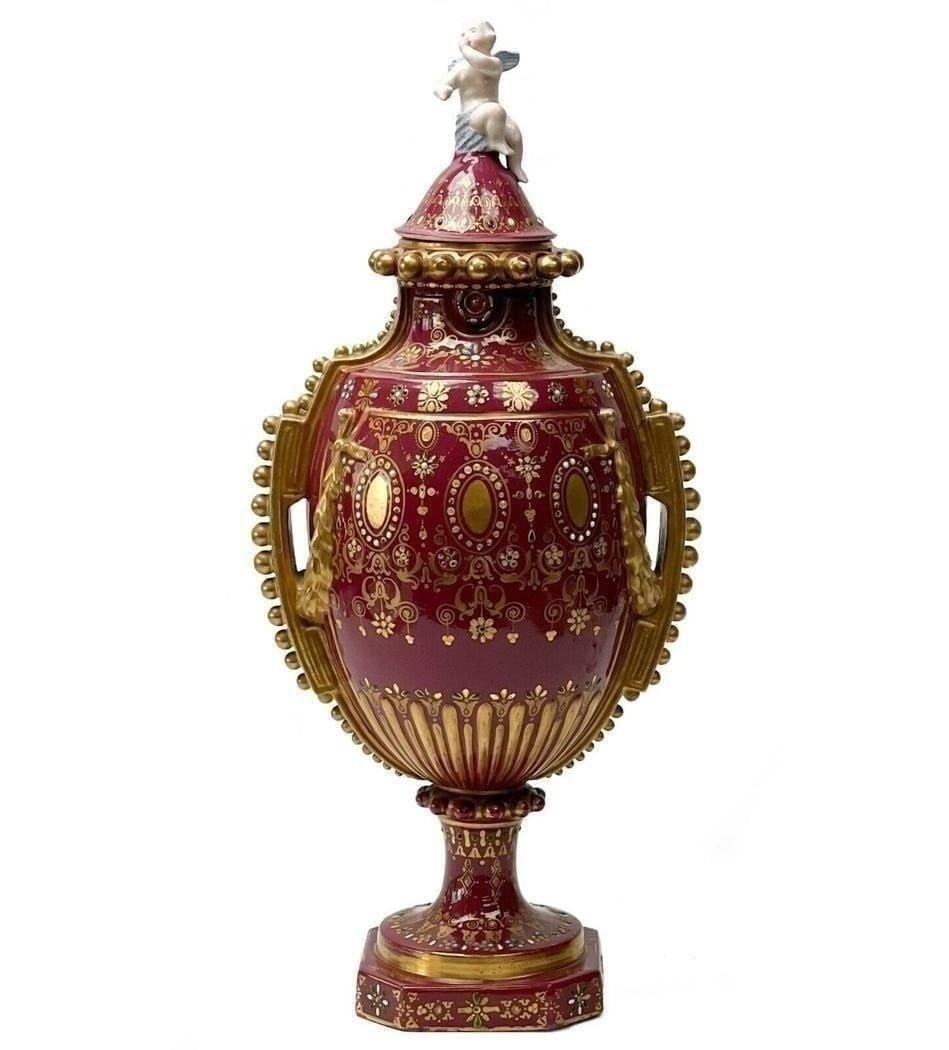 Sevres Style Hand Painted Porcelain Twin Handled Covered Urn circa 1900: Sevres Style hand painted porcelain covered urn, circa 1900. A deep magenta colored ground with relief gilt garland decoration, elaborate gilt designs throughout with turquoise, green, and white ename