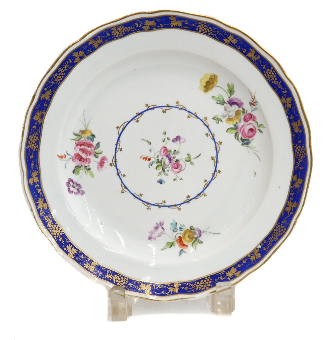 Derby English Porcelain Cobalt Blue and Gilt Floral Cabinet Plate circa 1780: Derby English porcelain cobalt blue and gilt scallop rimmed cabinet plate. Cobalt blue ground rim with hand painted florals to center. Gilt accents. Derby hallmark to underside. Weight: Approx. 1 lbs 