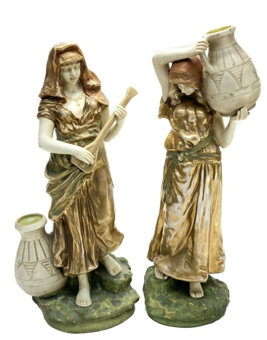 Pair Amphora Turn Imperial Porcelain Sculptures: Pair Amphora Turn Imperial porcelain sculptures, circa 1900. The sculptures depict two maidens in period era garbs- one holding a water vessel above her head, and the other with a water vessel by her 