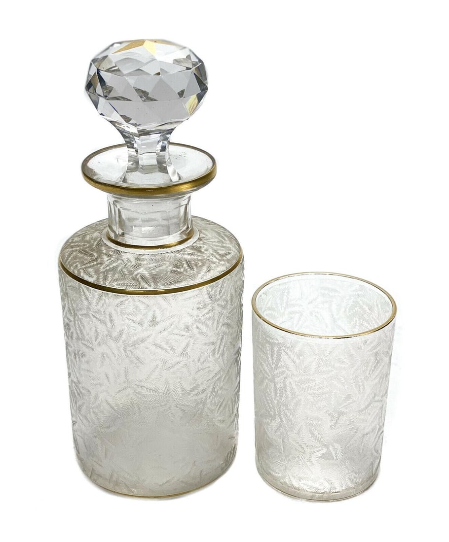 French Frosted and Clear Glass Decanter and Cup, circa 1920: French frosted and clear glass decanter and cup, circa 1920. Frosted leaf texture throughout the of the decanter and cup. Gilt to the circular bands. Unmarked, but is possibly from Saint Louis. Weight
