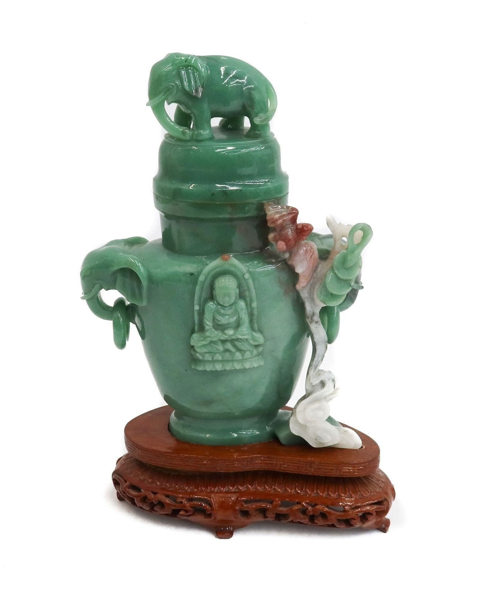 Chinese Carved Jade Decorative Urn on Base: Chinese Carved Jade Urn on Base. Figural elephant finial and handles with a carved relief Buddah to center. Mounted on a wood base. Weight Approx., 2 lbs Measures Approx., 6 inches x 2.5 inches x 9.5 