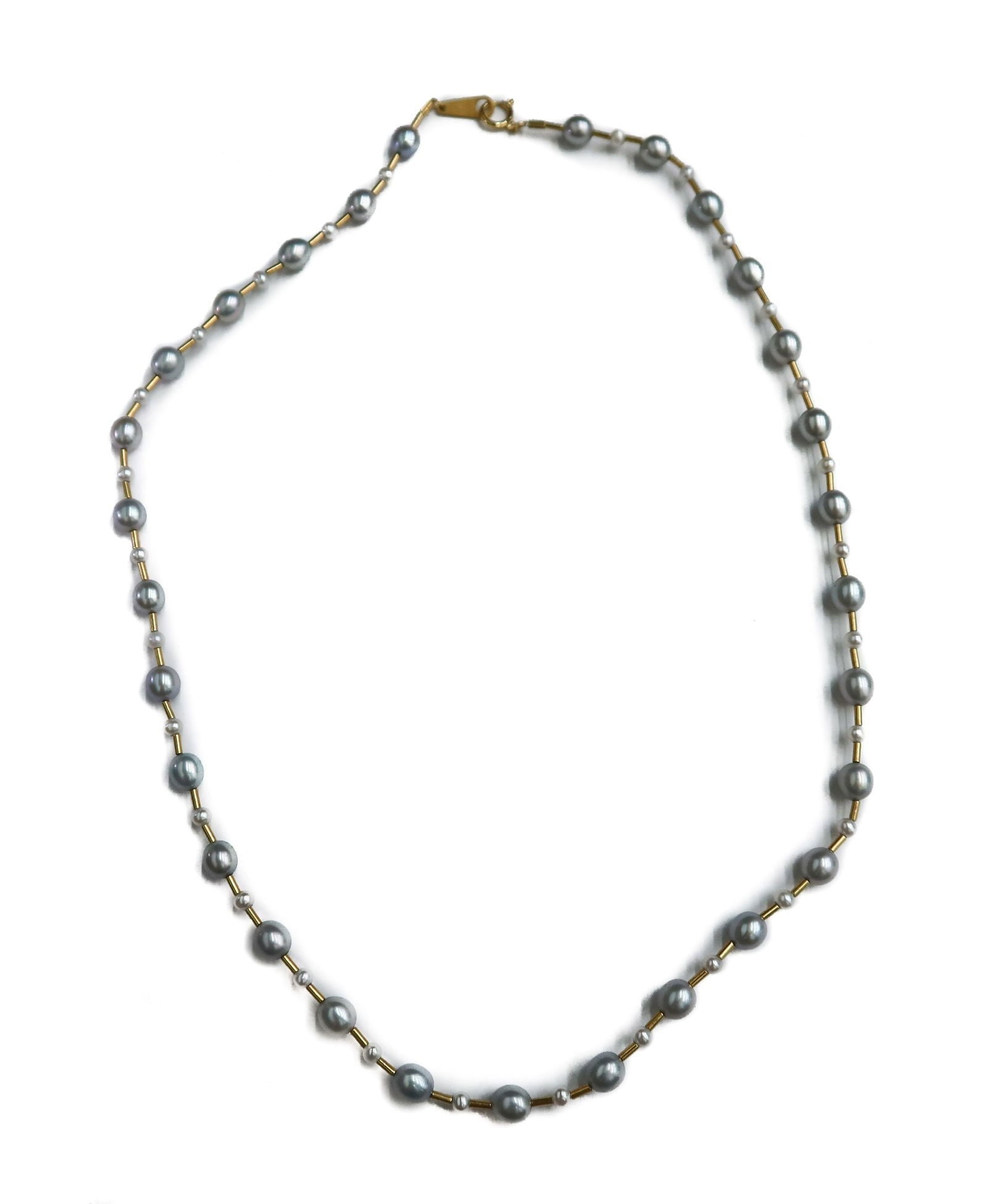 18k Yellow Gold and Grey Cultured Pearl Necklace: 18k Yellow Gold and Grey Cultured Pearl Necklace. Consisting of grey pearls of oval cut (5.7mm x 5.1mm) and round pearls (2.8mm) in an alternating pattern. Marked 18k to clasp. Weight Approx., 8.44 gr