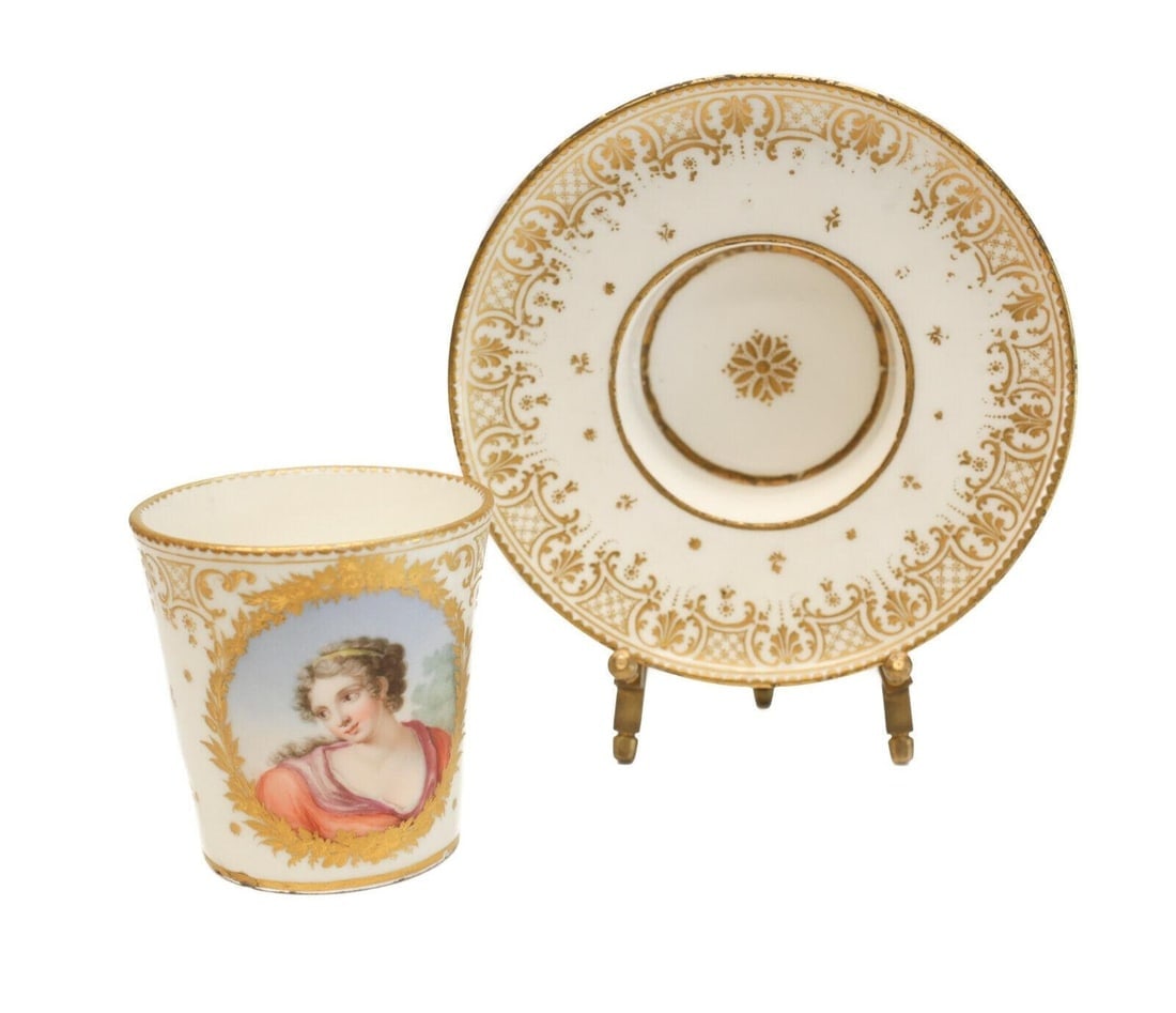 Fine Sevres Porcelain Cup & Saucer w/ Portrait Goblet et Sou Coupe Enfonce 1759: A fine 18th Century hand painted porcelain cup and socketed saucer- Goblet et Sou Coupe Enfonce by Sevres. The central image of the cup depicts a beautiful hand painted portrait of a woman in red garb