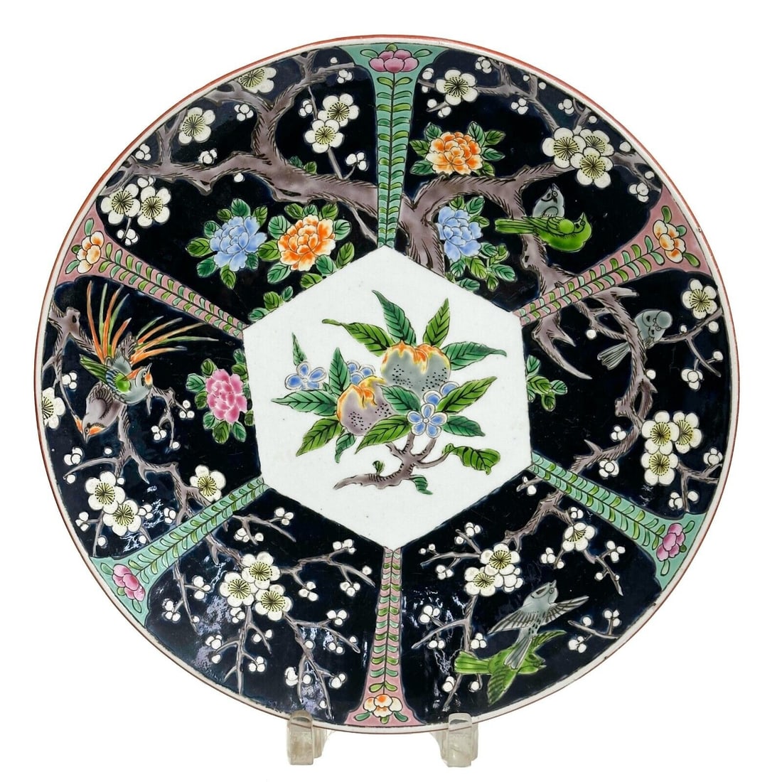 Japanese Enameled Porcelain Charger Plate Showa Period: Japanese Enameled Porcelain Charger, Showa period. A black ground to the edge with scenes of birds in trees, hexagonal shape to center with fruit. Underside with Japanese maker's mark, impressed mark 
