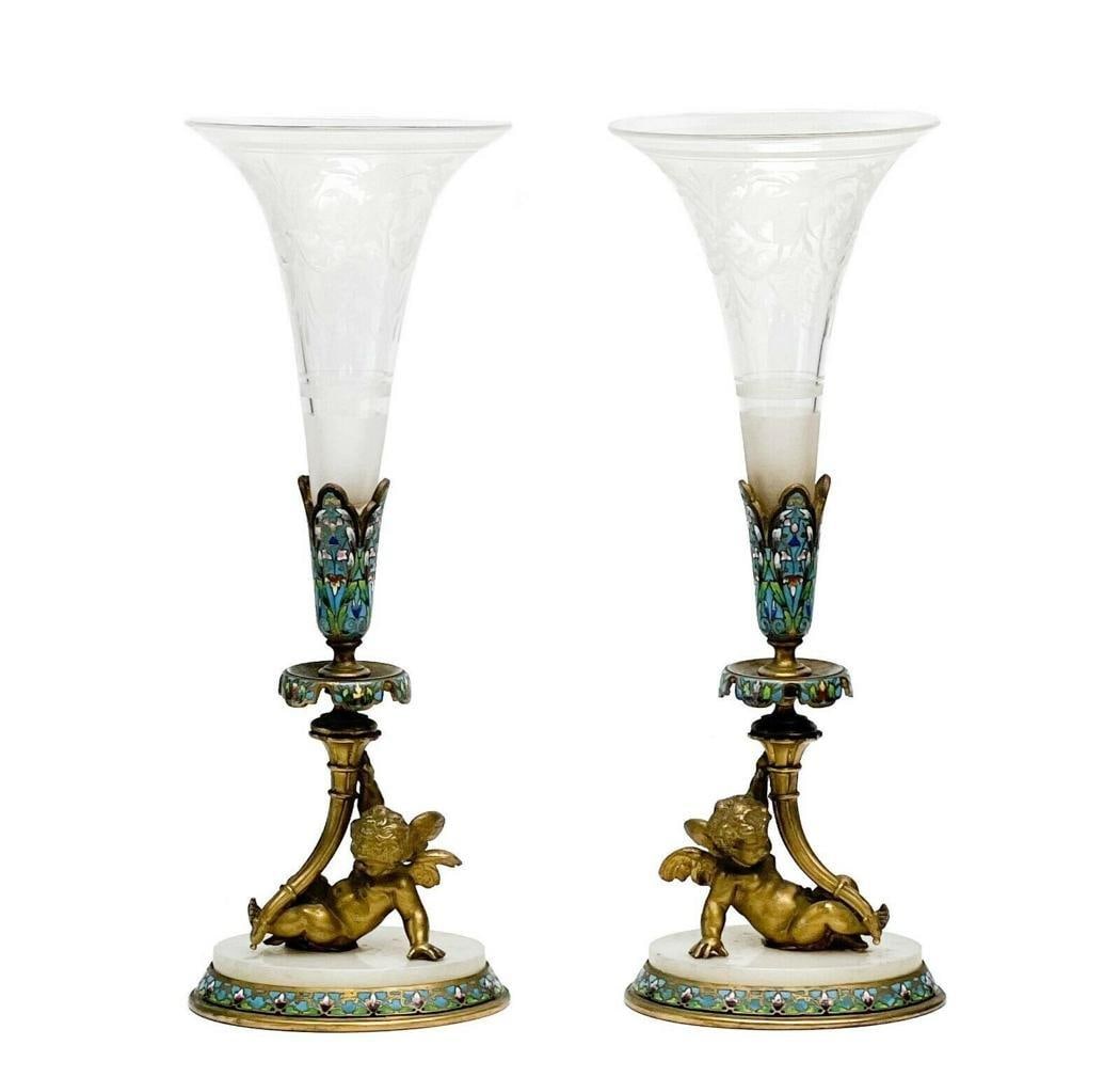 Pair French Champleve Enamel Bronze Putti Engraved Glass Trumpet Form Vases: Pair of French Champlevé enamel gilt bronze putti mounted engraved glass trumpet form vases, late 19th century. Clear glass vases with etched floral and garland decoration. Gilt bronze figural putti 