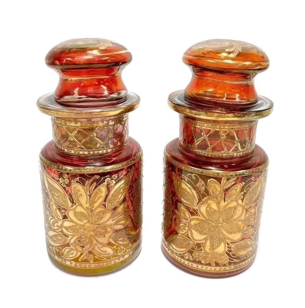 Pair Bohemian Cranberry Red Gold Encrusted Lidded Jars, 3rd Quarter 20th Century: Pair Bohemian glass cranberry red gold encrusted lidded jars, 3rd Quarter 20th Century. Cranberry red with gold encrusted florals and leaves. Weight Approx., 1 lbs Measures Approx., 4 inches diameter 