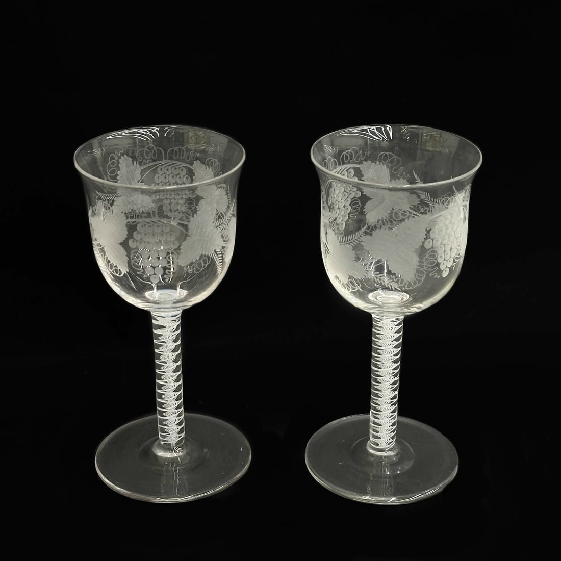 Pair English Air Twist Engraved Grapevine 6 in Wine Glasses 19th century: Pair English Air Twist Engraved Glasses, 19th century, possibly earlier. Engraved grapevine decoration to bowl, air twist stems. Polished pontil to the underside. Weight: Approx. 1 lb Measurements: Ap