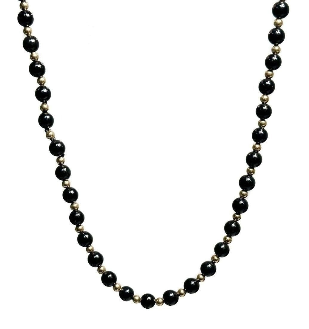 Black Onyx and Gold Beaded Single Strand Necklace: Black Onyx and Gold Beaded Single Strand Necklace. Black onyx beads measuring 7mm with alternating gold spacers weighing carats. Weight Approx., 35.35 grams Measures Approx., 30 inches length Domestic