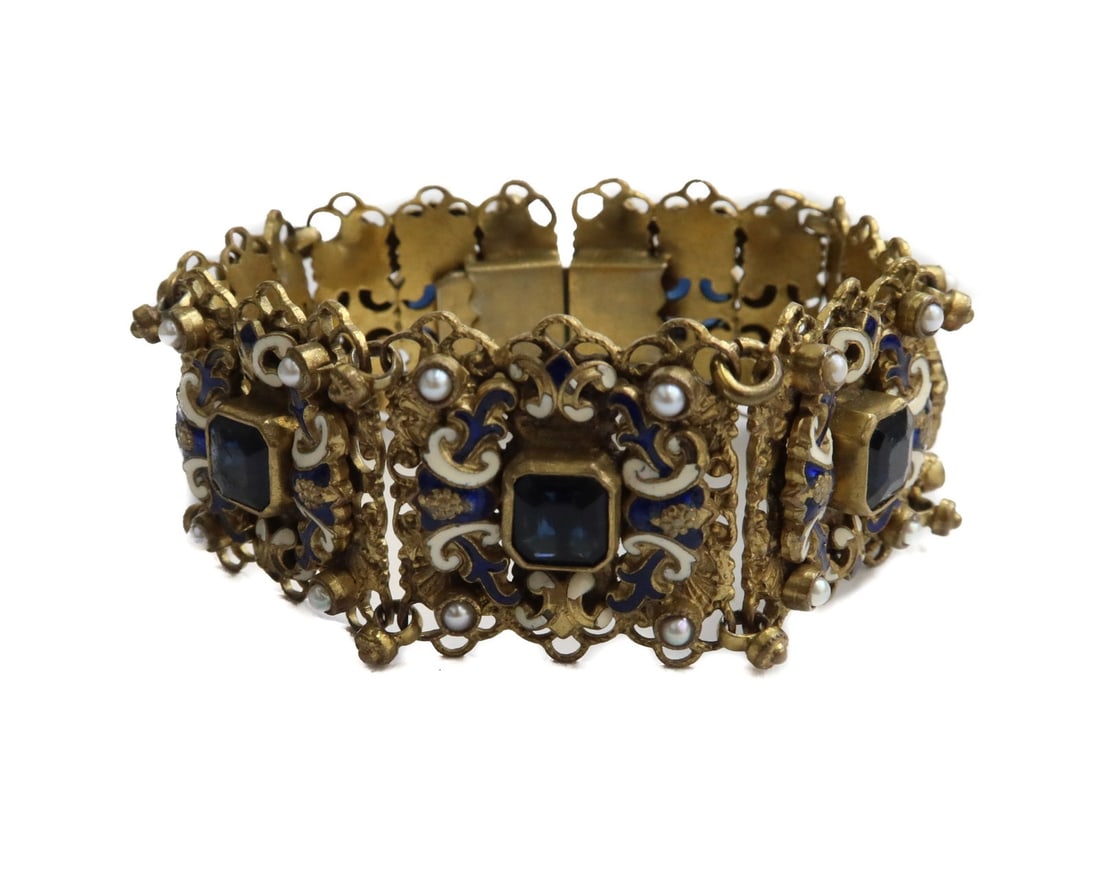 Austrian Gilt Metal Enamel and Glass Link Bracelet: Austrian Gilt Metal Enamel and Glass Link Bracelet. Blue and white enamel with 7 blue glass jewels to center. Marked Austria. Weight Approx., 50 grams Measures Approx., 6.75 inches length Domestic Shi