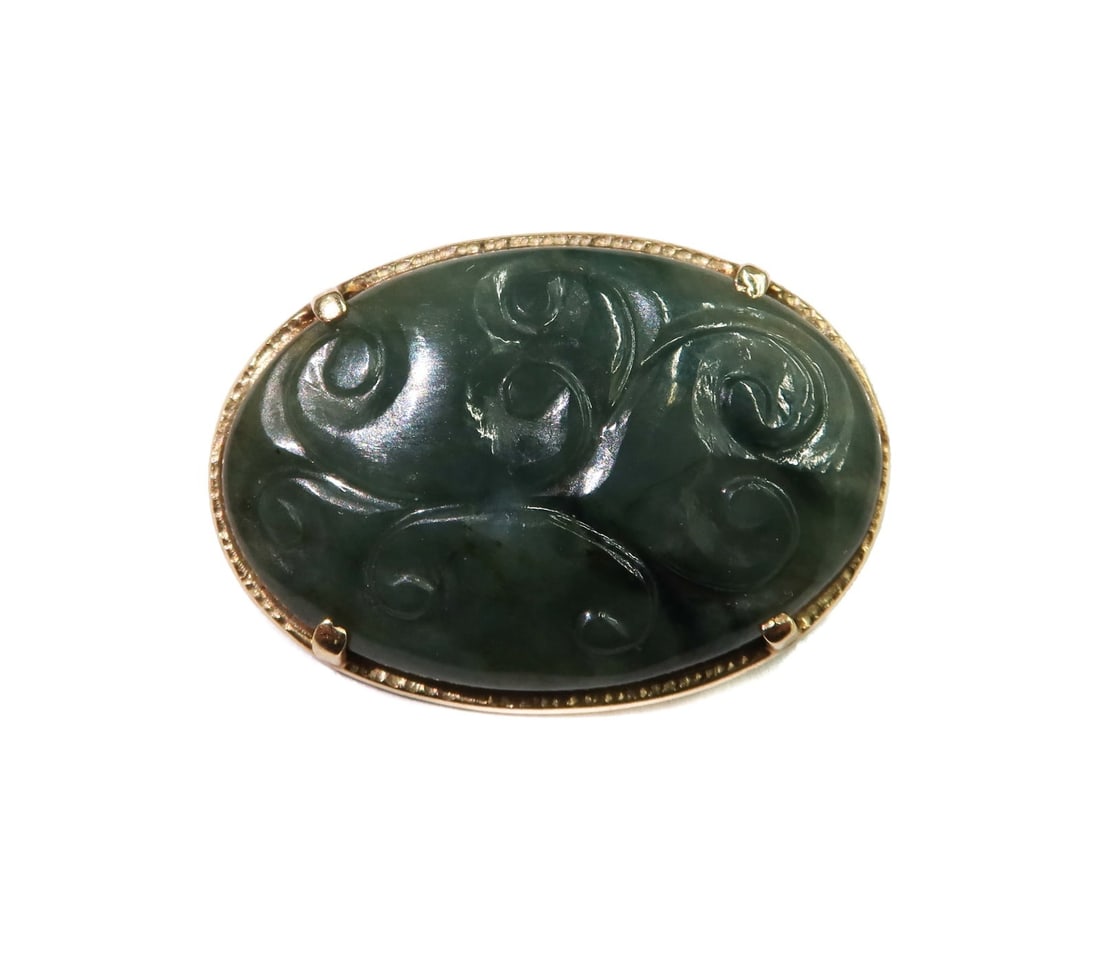 Ming's 14k Yellow Gold and Jade Carved Pendant: Ming's 14k Yellow Gold and Jade Carved Pendant. Etched swirls to jade. Marked "Wing's 14k" to edge. Weight Approx., 7.70 grams Measures Approx., 1.25 inches x 0.875 inches Domestic Shipping:$25