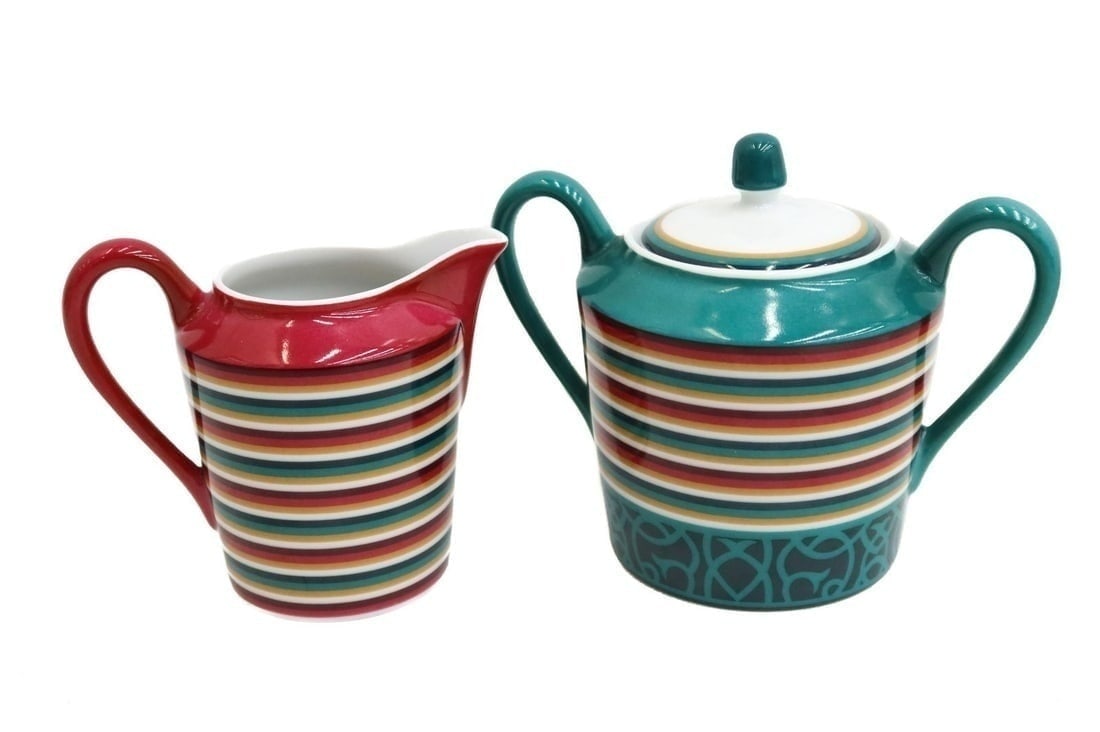 Hermes Paris Porcelain Sugar Bowl and Creamer in Attelage Green and Red Stripes: Hermes Paris porcelain sugar bowl and creamer in Attelage. Red and green stripes to rim. Hermes mark to underside. Weight Approx., 1 lbs Measures Approx., Sugar Bowl: 5.5 inches x 3.5 inches diameter 
