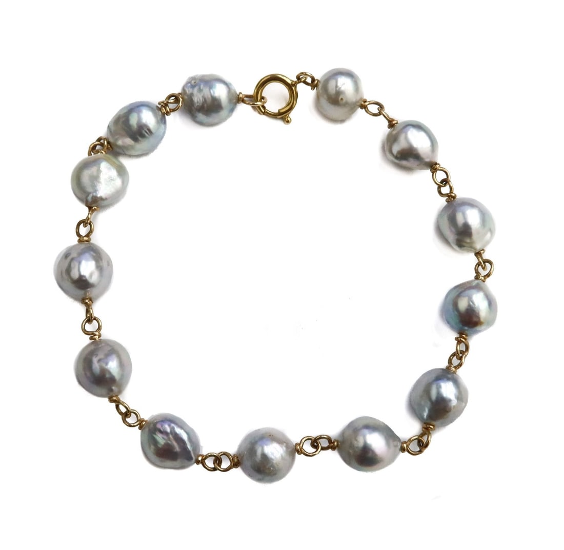 14k Yellow Gold and Baroque Silver Pearl Bracelet: 14k yellow gold and silver baroque pearl bracelet. The pearls measuring approximately 7.66mm to 8.33mm. Marked 14k to clasp. Weight: Approx. 11 grams Measurements: Approx. 8 inches length Condition: G