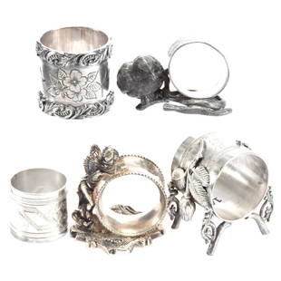 (5) Silverplate Napkin Rings: (5) Silverplate Napkin Rings Including - (1) Meriden #226 with Chick and Branch - (1) Winged Cherub - (1) Floral Branch Design - (2) with Engraved Designs, One Dated 1895 - See Photos for Details