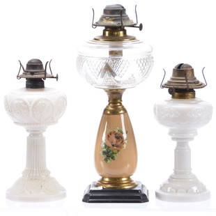 (3) Kerosene Lamps, Various: (3) Kerosene Lamps; (1) 14" Clear Zig Zag and Diamond Font with Brown Fireglow Stem, Metal Base; (1) 9.5" Milk Glass Grape Chain of Leaves Pattern; (1) 10" Milk Glass Daisy Pattern by Westmoreland