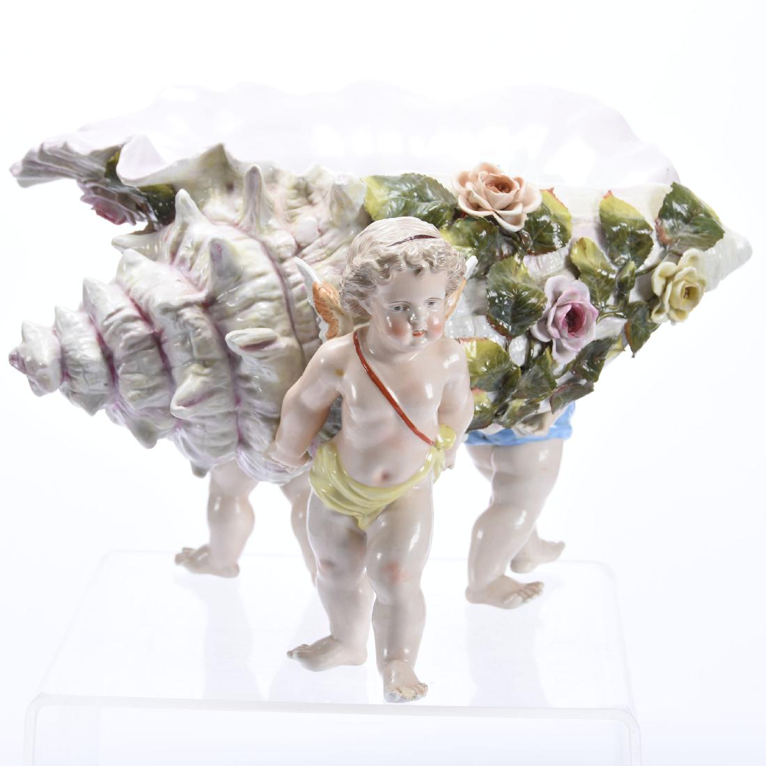 Center Piece, Sitzendorf Style: Figural Sitzendorf Style Center Piece, 11" X 17" Three Full Figure Winged Cherubs Holding Conch Shell, Applied Floral Highlights, One Cherub Has One Toe Chipped, Minor Chips on Flowers