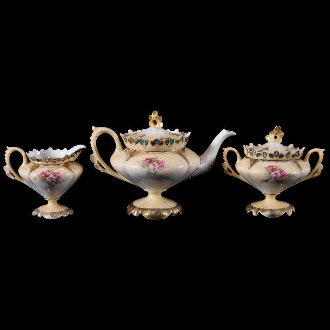 Three Piece R.S. Prussia Pedestal Tea Set: Three Piece R.S. Prussia Pedestal Tea Set, Cream and White Tones with Pink Rose Decor, Pale Blue Jewel Highlights, Nice Gold, Possible Finial Repair on Both Lids
