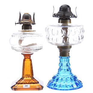 (2) Kerosene Lamps: (2) Kerosene Lamps; (1) 11" Round Blue Pattern Glass Base with Clear Font; (1) 10" Square Amber Base with Clear Font