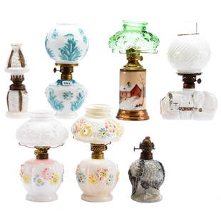 (7) Miniature Kerosene Lamps: (7) Miniature Kerosene Lamps; (1) 8.25" Milk Glass with Blue Floral Highlights; (2) Cosmos Lamps, One Is Milk Glass, One Painted; (1) Elephant Lamp; (1) Fireglow Base with Green Cosmos Shade; (1)