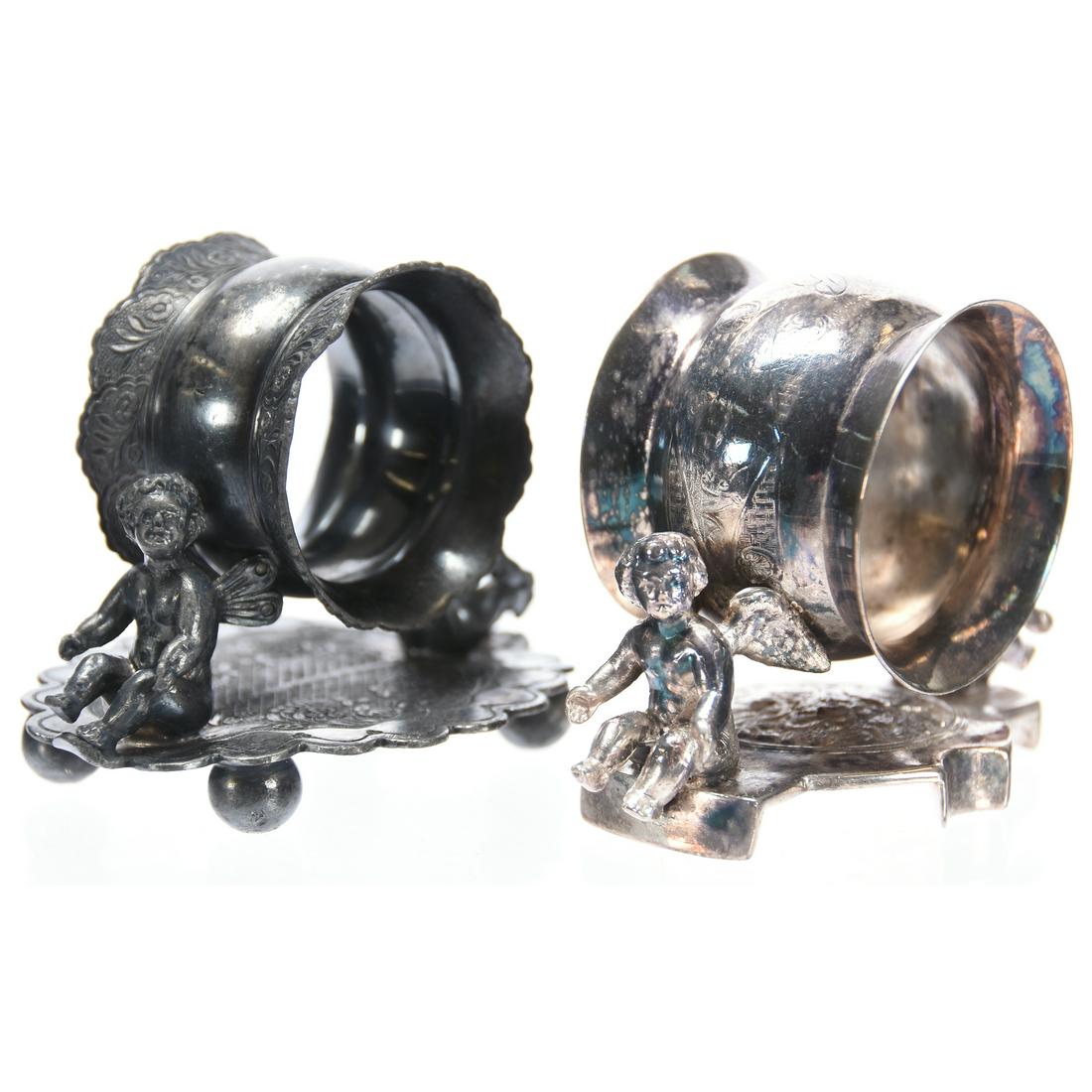 (2) Figural Silverplate Napkin Rings: (2) Figural Silverplate Napkin Rings Similar in Style Featuring Two Cherubs; (1) Wilcox #01536; (1) Webster #170
