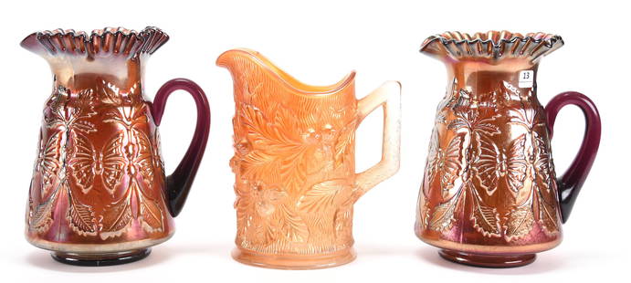 (3) Carnival Glass Water Pitchers W/ Damage/Repair: (3) Carnival glass water pitchers with damage/repair; 9.5", 9" (2) 9.5" Butterfly & Fern pattern by Fenton, Amethyst, crack in body near handles; (1) 9" Acorn & Burrs pattern by Northwood, Marigold,