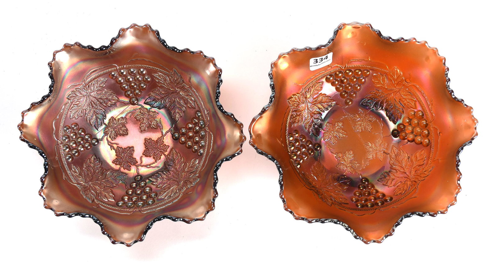 (2) Carnival Glass Spatula Footed Bowls by Fenton: (2) Carnival glass spatula footed bowls by Fenton; 7.75" Grape & Cable pattern, Amethyst, ruffled; Don Anderson Collection, Kansas