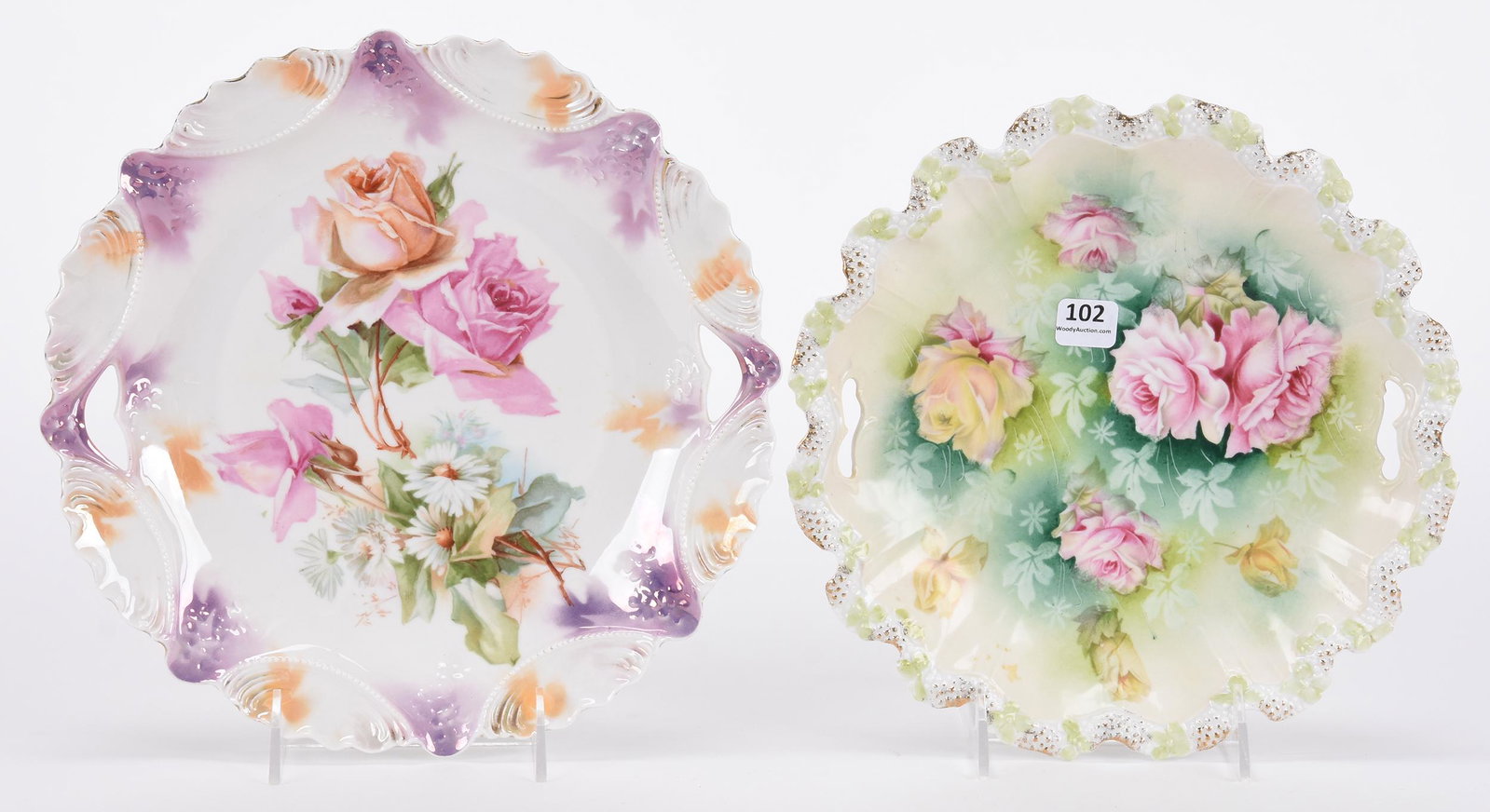 (2) Cake plates, one marked R.S. Prussia, one unmarked: (2) Cake plates, one marked R.S. Prussia, one unmarked; 10.25", 9.5" (1) Marked R.S. Prussia, white lavender and orange lustre finish with rose and daisy decor; (1) Unmarked Prussia, stipple mold, gre