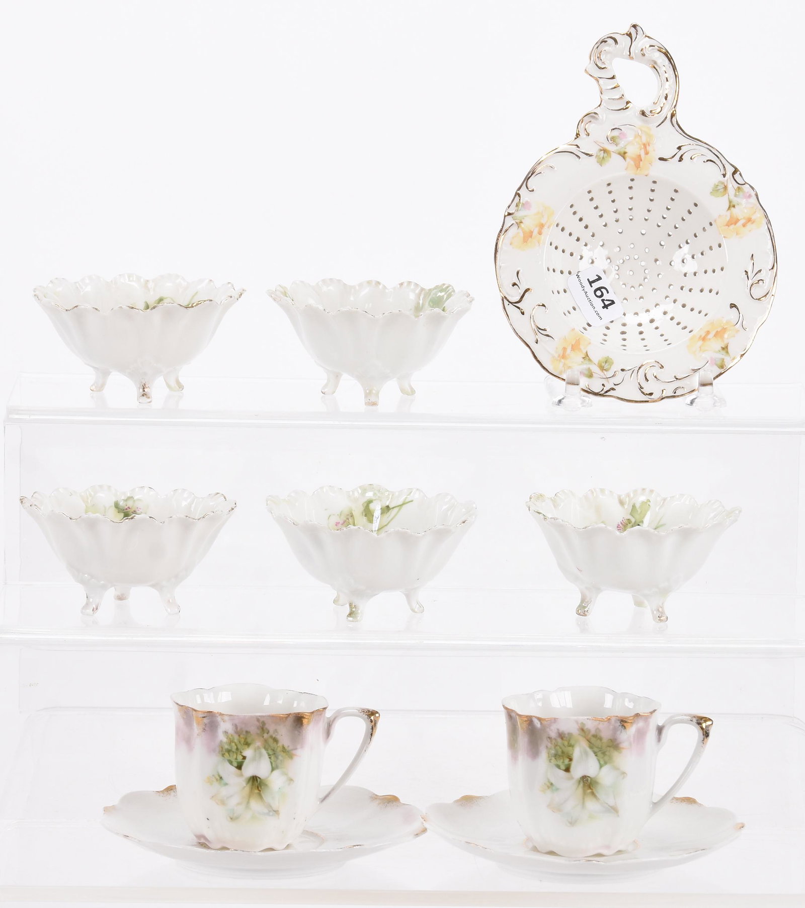 (8) Assorted Prussia style items: (8) Assorted Prussia style items; (1) 5.75" unmarked tea strainer; (5) marked R.S. Prussia footed nut dishes; (2) demitasse cups and saucers with Easter lily decor, one cup is marked ; Hopper Collecti